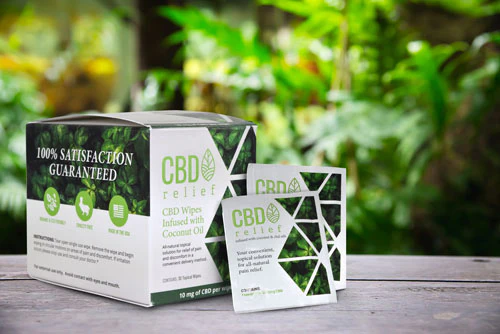 Box and two packs of CBD Wipes in front of a forest background